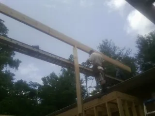 Carpenter setting a ridge beam over a new addition frame — Ice Dam Removal by Roofing Brothers in Chester Springs