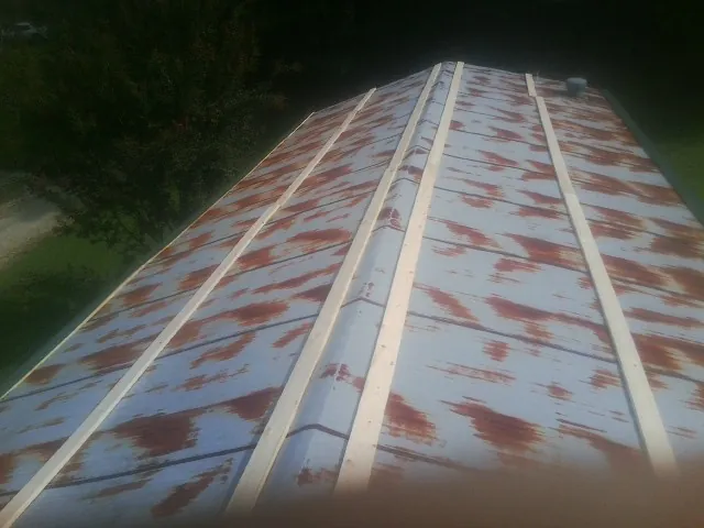 Rusted metal roof panels with new wood purlins before replacement — Storm Damage Roof Repair in Chester Springs by Roofing Brothers