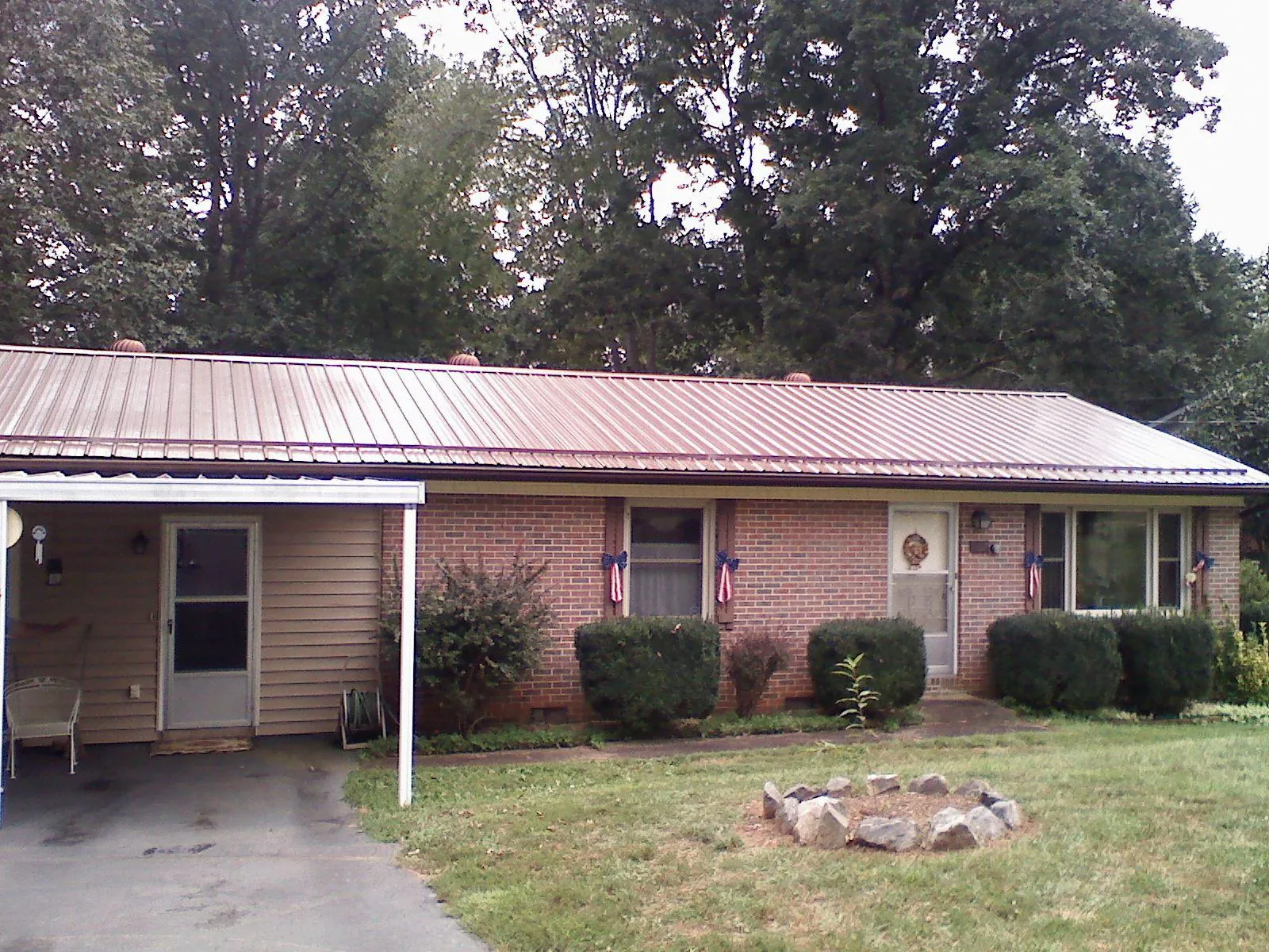 Bronze metal roof and carport on a brick ranch home — Roof Repair work by our crew in Chester Springs